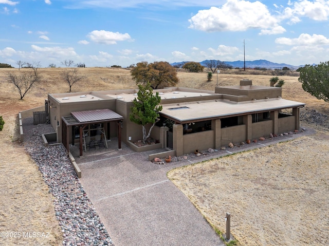 view of front of home featuring a chimney, a mountain view, a rural view, and aphalt driveway