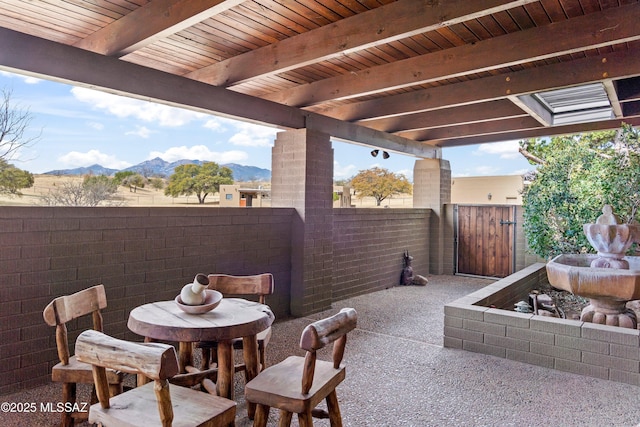 view of patio / terrace featuring a gate, a mountain view, and fence