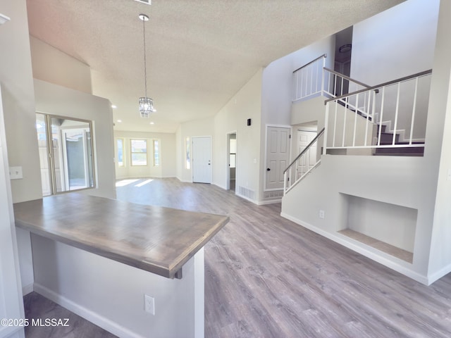 3438 Avenida Del Pueblo, Tucson, AZ 85746 - unfurnished living room with stairway, baseboards, wood finished floors, and a textured ceiling