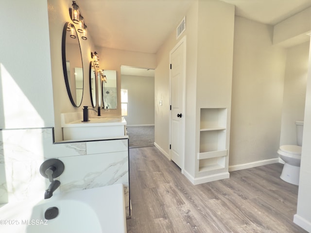 3438 Avenida Del Pueblo, Tucson, AZ 85746 - bathroom featuring wood finished floors, vanity, baseboards, toilet, and visible vents