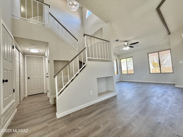 3438 Avenida Del Pueblo, Tucson, AZ 85746 - unfurnished living room featuring ceiling fan, baseboards, a textured ceiling, and stairway