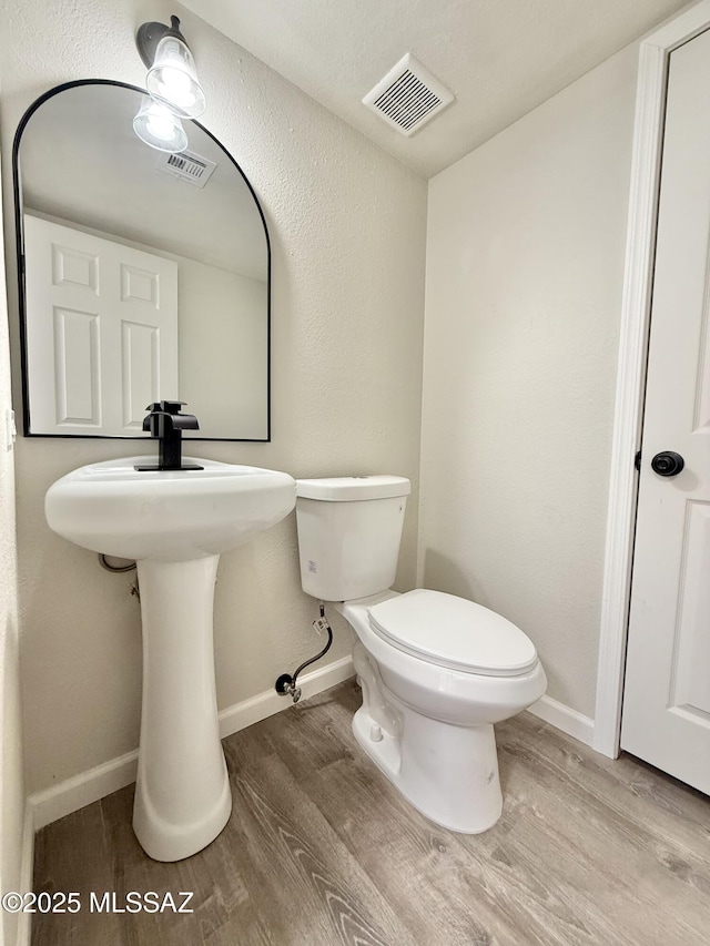 3438 Avenida Del Pueblo, Tucson, AZ 85746 - half bathroom with baseboards, wood finished floors, visible vents, and toilet
