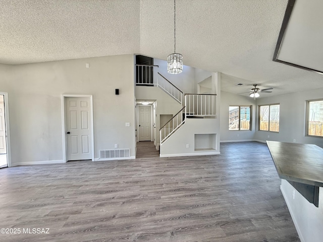 3438 Avenida Del Pueblo, Tucson, AZ 85746 - unfurnished living room featuring wood finished floors, visible vents, a textured ceiling, and vaulted ceiling