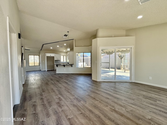 3438 Avenida Del Pueblo, Tucson, AZ 85746 - unfurnished living room featuring dark wood-type flooring, lofted ceiling, a textured ceiling, and recessed lighting