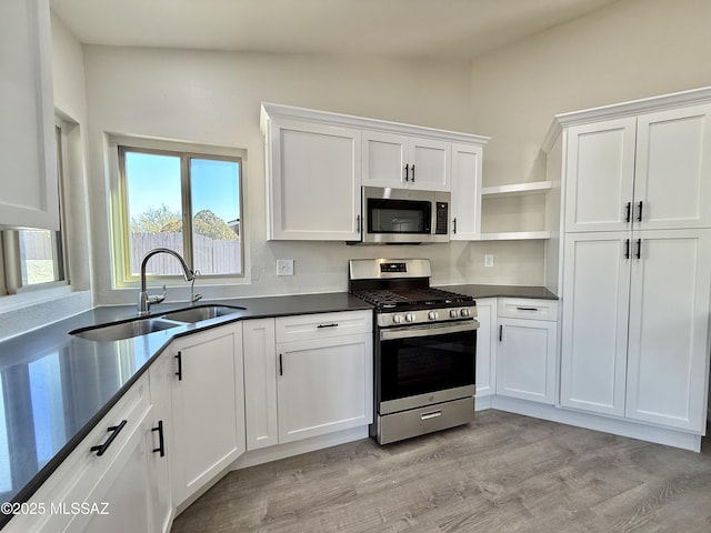 3438 Avenida Del Pueblo, Tucson, AZ 85746 - kitchen with dark countertops, open shelves, a sink, white cabinetry, and appliances with stainless steel finishes