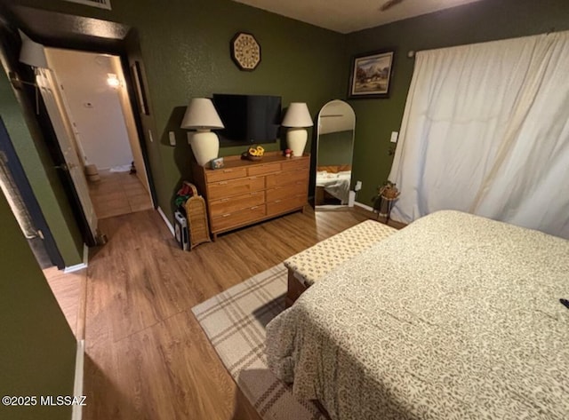 bedroom with baseboards and wood finished floors