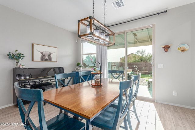 dining space featuring baseboards, visible vents, and light wood-type flooring