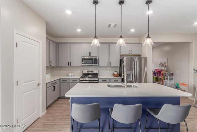 kitchen with visible vents, gray cabinets, light wood-style floors, and appliances with stainless steel finishes