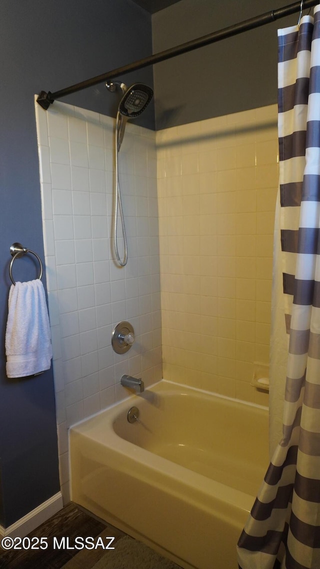 full bath featuring baseboards and shower / bathtub combination with curtain