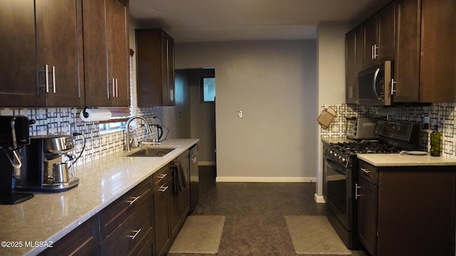 kitchen with baseboards, decorative backsplash, a sink, dark brown cabinets, and appliances with stainless steel finishes
