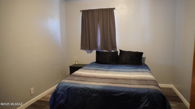 bedroom featuring baseboards and dark wood-style floors