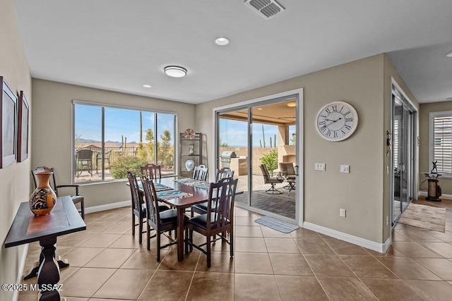 tiled dining space with baseboards and visible vents