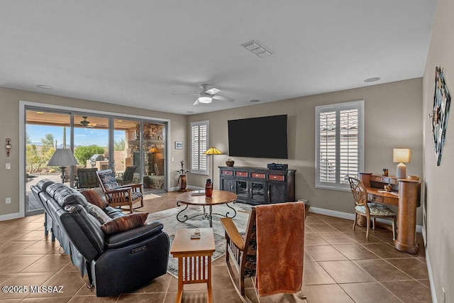 living area featuring tile patterned floors, a healthy amount of sunlight, ceiling fan, and visible vents