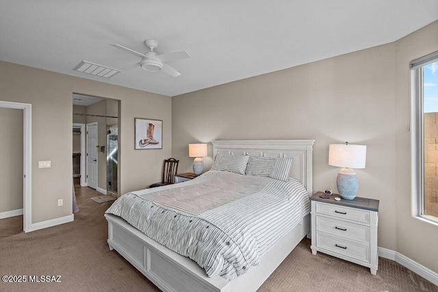 bedroom featuring light carpet, baseboards, visible vents, and a walk in closet