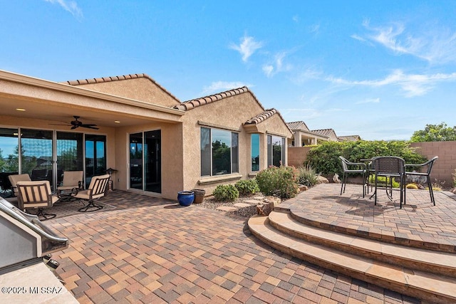 view of patio featuring outdoor dining space, fence, and ceiling fan