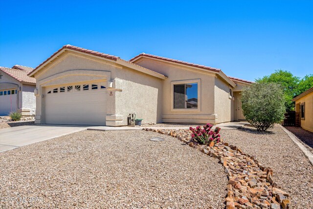 ranch-style home with stucco siding, driveway, an attached garage, and a tile roof