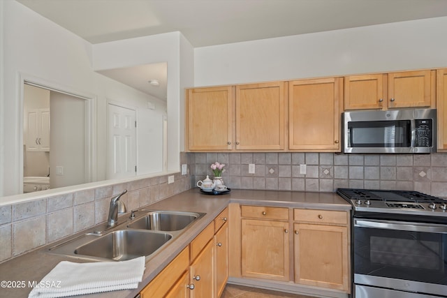 kitchen featuring light brown cabinetry, a sink, appliances with stainless steel finishes, and tasteful backsplash