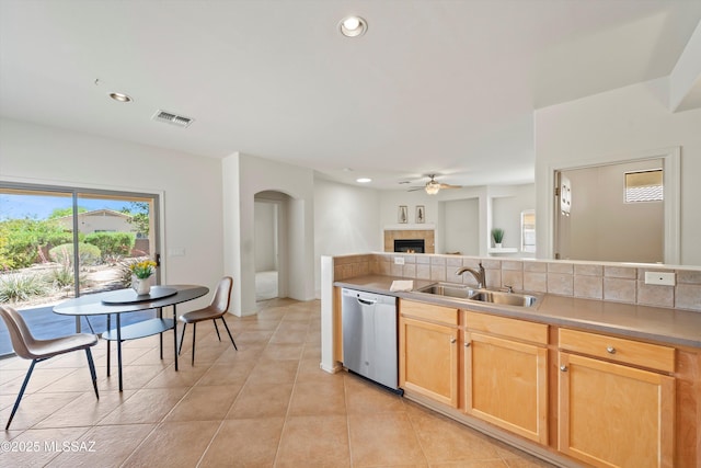 kitchen with light brown cabinets, ceiling fan, dishwasher, a sink, and visible vents