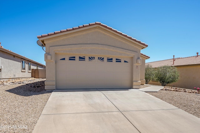 exterior space with an attached garage, stucco siding, concrete driveway, and a tiled roof
