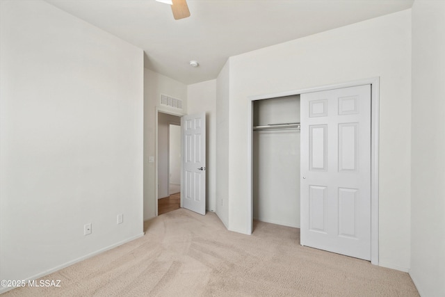 unfurnished bedroom with a closet, visible vents, carpet floors, and baseboards