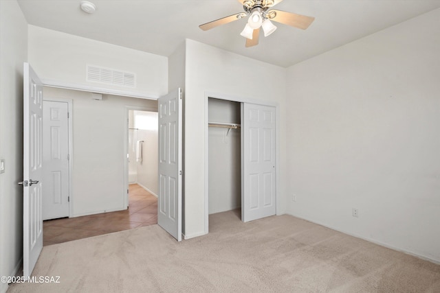 unfurnished bedroom featuring a closet, visible vents, ceiling fan, and carpet