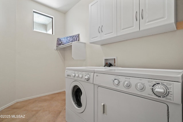 clothes washing area with light tile patterned floors, cabinet space, baseboards, and washer and clothes dryer