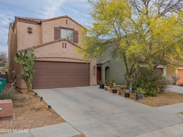 mediterranean / spanish-style house with driveway, stucco siding, and a tiled roof