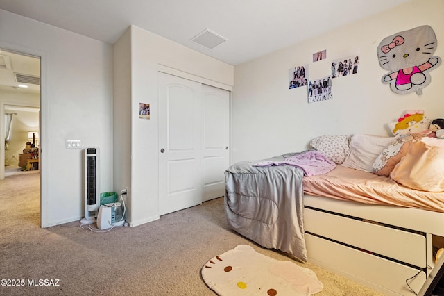 bedroom with a closet, visible vents, and carpet