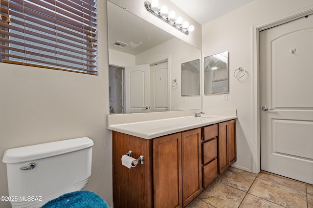 bathroom with vanity, visible vents, and toilet