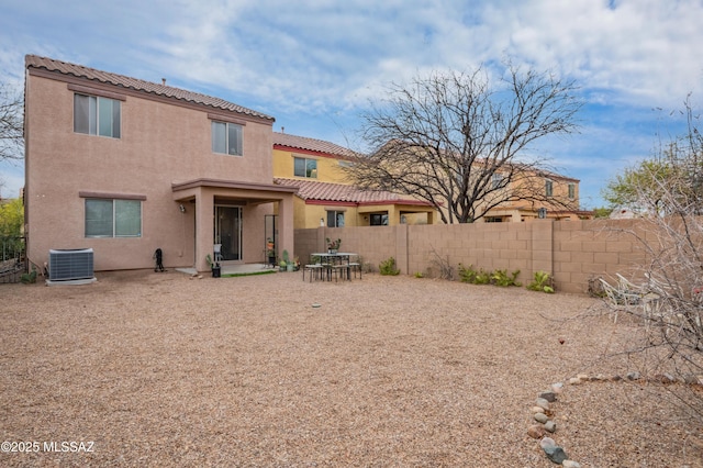 rear view of house with a patio, stucco siding, cooling unit, a tile roof, and fence