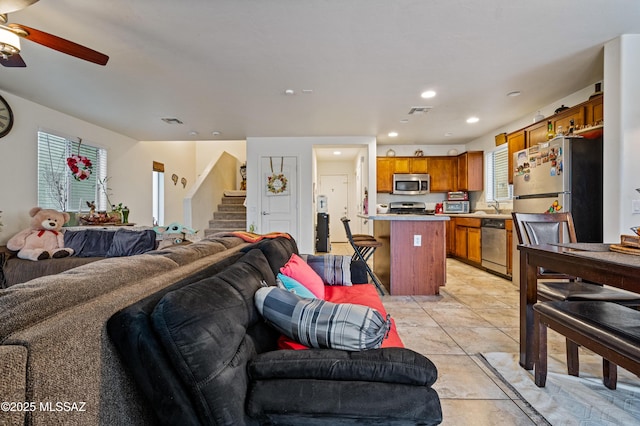 living area featuring recessed lighting, stairs, visible vents, and a ceiling fan