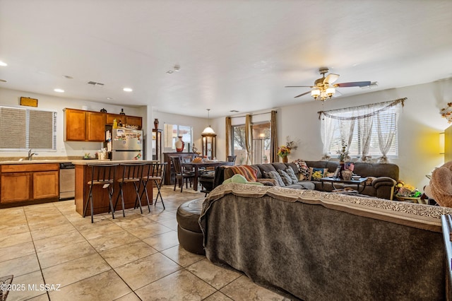 living room with light tile patterned flooring, ceiling fan, visible vents, and recessed lighting
