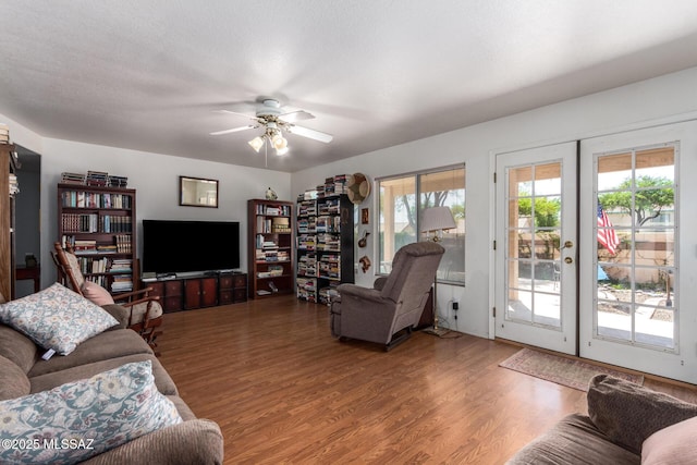 living room with french doors, a ceiling fan, and wood finished floors