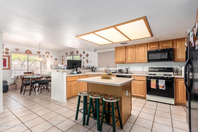 kitchen featuring light countertops, black appliances, a peninsula, and light tile patterned flooring