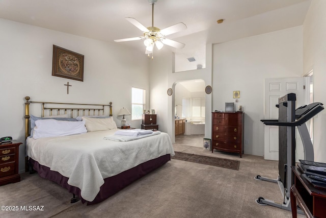 carpeted bedroom with visible vents, connected bathroom, ceiling fan, and high vaulted ceiling