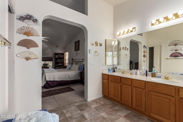 ensuite bathroom with double vanity, a ceiling fan, a sink, and ensuite bathroom