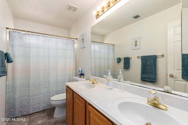 bathroom with visible vents, a sink, double vanity, and toilet