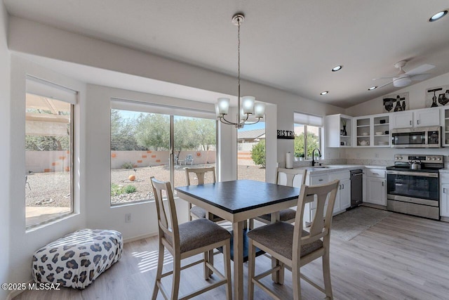 36526 S Wind Crest Dr, Tucson, AZ 85739 - dining area featuring ceiling fan with notable chandelier, vaulted ceiling, light wood-style floors, and recessed lighting
