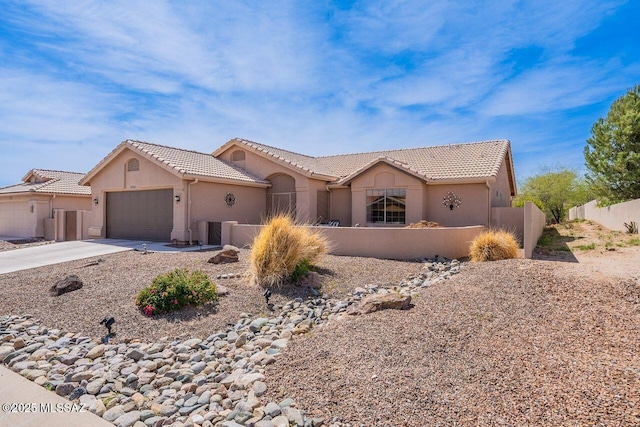 36526 S Wind Crest Dr, Tucson, AZ 85739 - view of front of house featuring a tile roof, driveway, stucco siding, an attached garage, and a fenced front yard