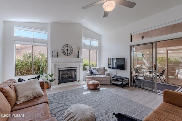36526 S Wind Crest Dr, Tucson, AZ 85739 - living room with high vaulted ceiling, light wood-type flooring, a tiled fireplace, and ceiling fan
