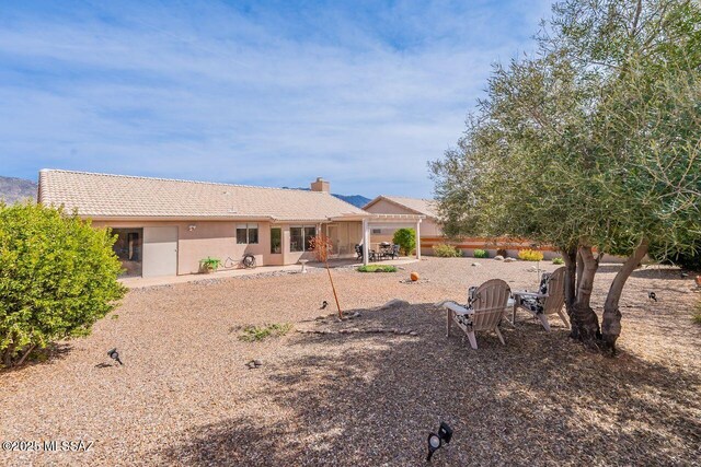 36526 S Wind Crest Dr, Tucson, AZ 85739 - rear view of house with a tiled roof, stucco siding, a patio, and a chimney