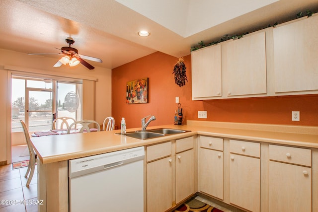 kitchen with light countertops, a peninsula, a ceiling fan, a sink, and white dishwasher