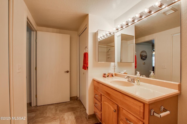 bathroom with vanity, a textured ceiling, and visible vents
