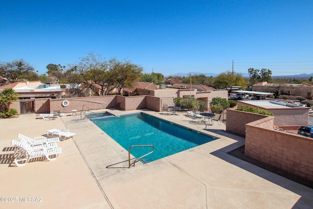 pool with a patio and fence