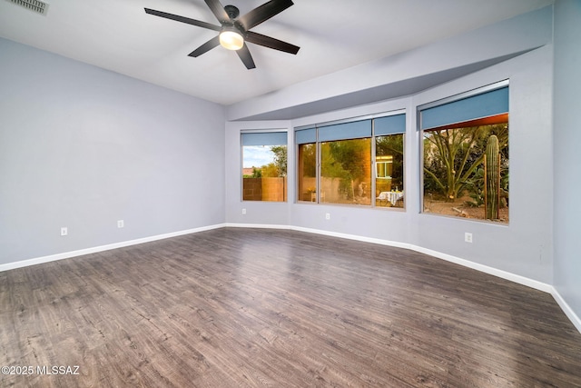 unfurnished room featuring visible vents, baseboards, ceiling fan, and dark wood-style floors