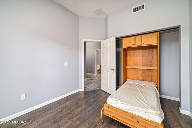 bedroom featuring baseboards, vaulted ceiling, visible vents, and dark wood-style floors