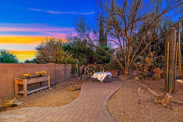 yard at dusk featuring a patio area and fence private yard