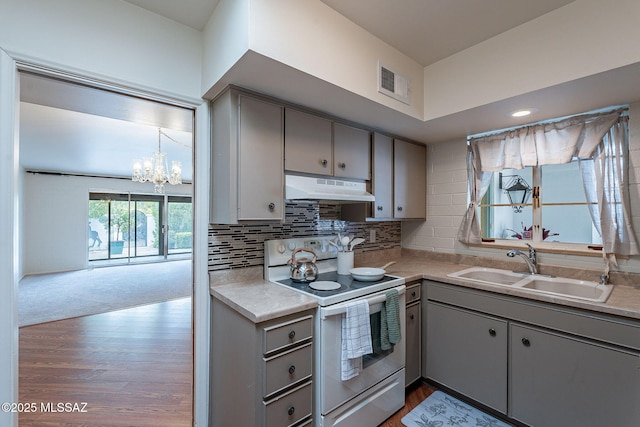 kitchen with gray cabinets, a sink, under cabinet range hood, electric stove, and visible vents