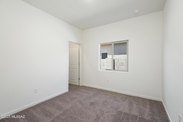 empty room featuring baseboards and carpet
