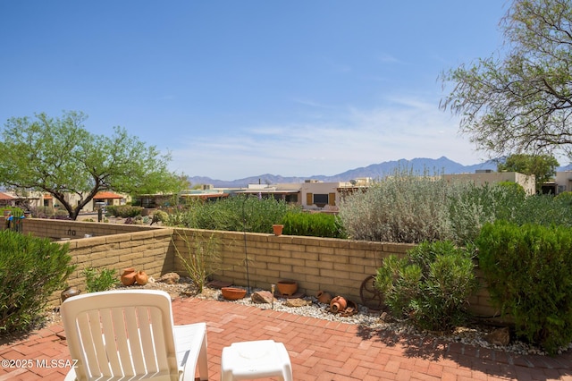 view of patio / terrace with a mountain view and a fenced backyard